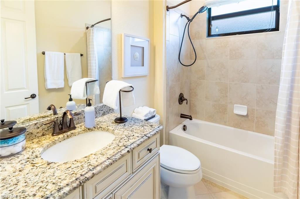 9372 Vercelli Court Naples, FL 34113 - Photo 31 of 50 Full bathroom featuring shower / bath combo, tile patterned floors, vanity, and toilet