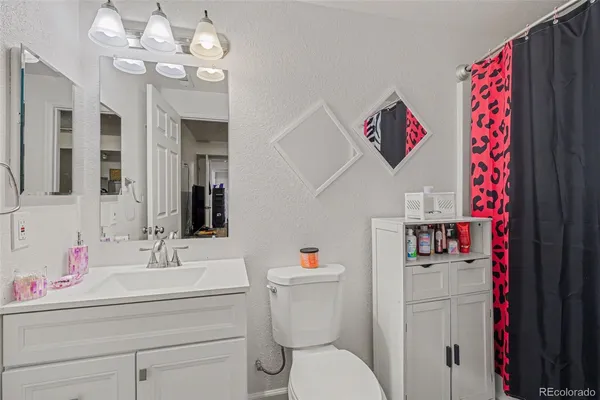 a bathroom with a sink vanity mirror and toilet