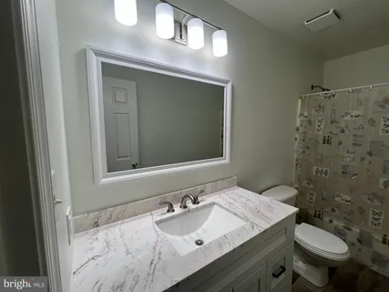 a living room with furniture and a air conditioner vent