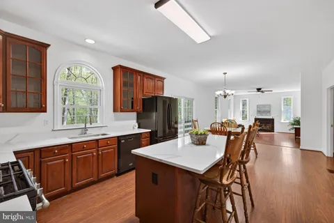 a kitchen with a refrigerator a stove top oven a sink dishwasher and wooden floor