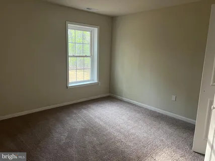 a view of an empty room with window wooden floor and a window