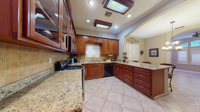a large kitchen with stainless steel appliances granite countertop a large stove a sink dishwasher and cabinets
