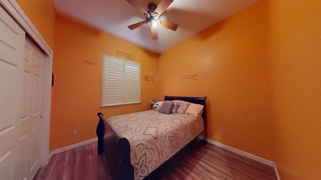 a bedroom with bed and wooden floor