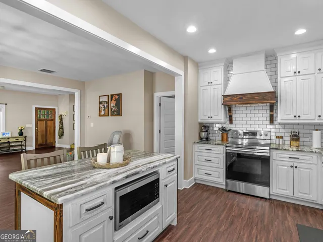 a kitchen with stainless steel appliances granite countertop a stove cabinets and wooden floor