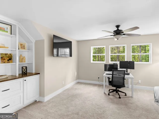 a view of a workspace with furniture and a window