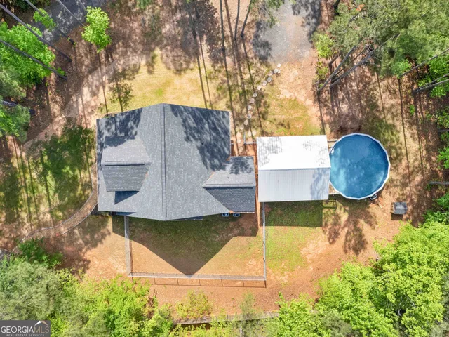 a aerial view of a house with swimming pool and large trees