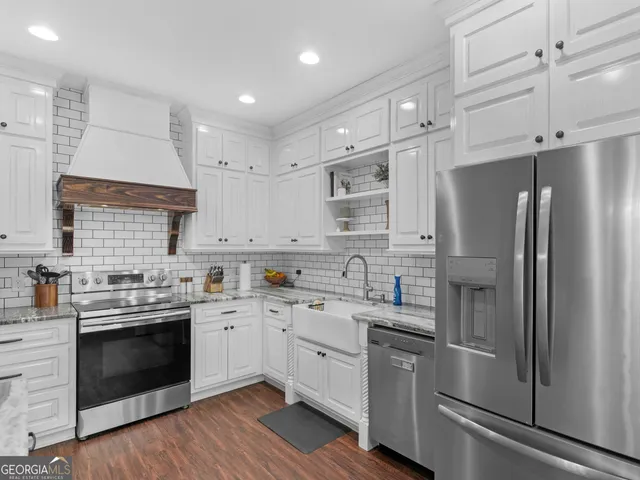 a kitchen with a sink stainless steel appliances and white cabinets