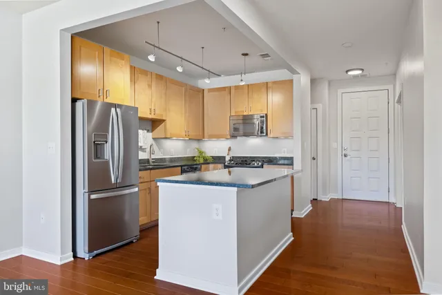 a kitchen with stainless steel appliances granite countertop a sink a stove and a refrigerator