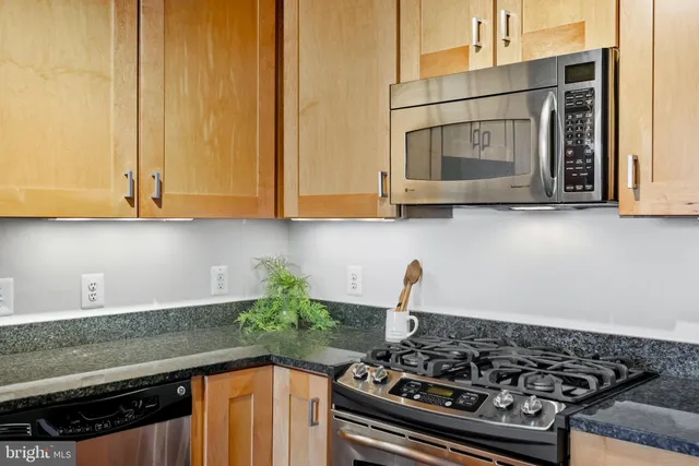 a bathroom with a granite countertop sink a toilet a mirror and shower curtain