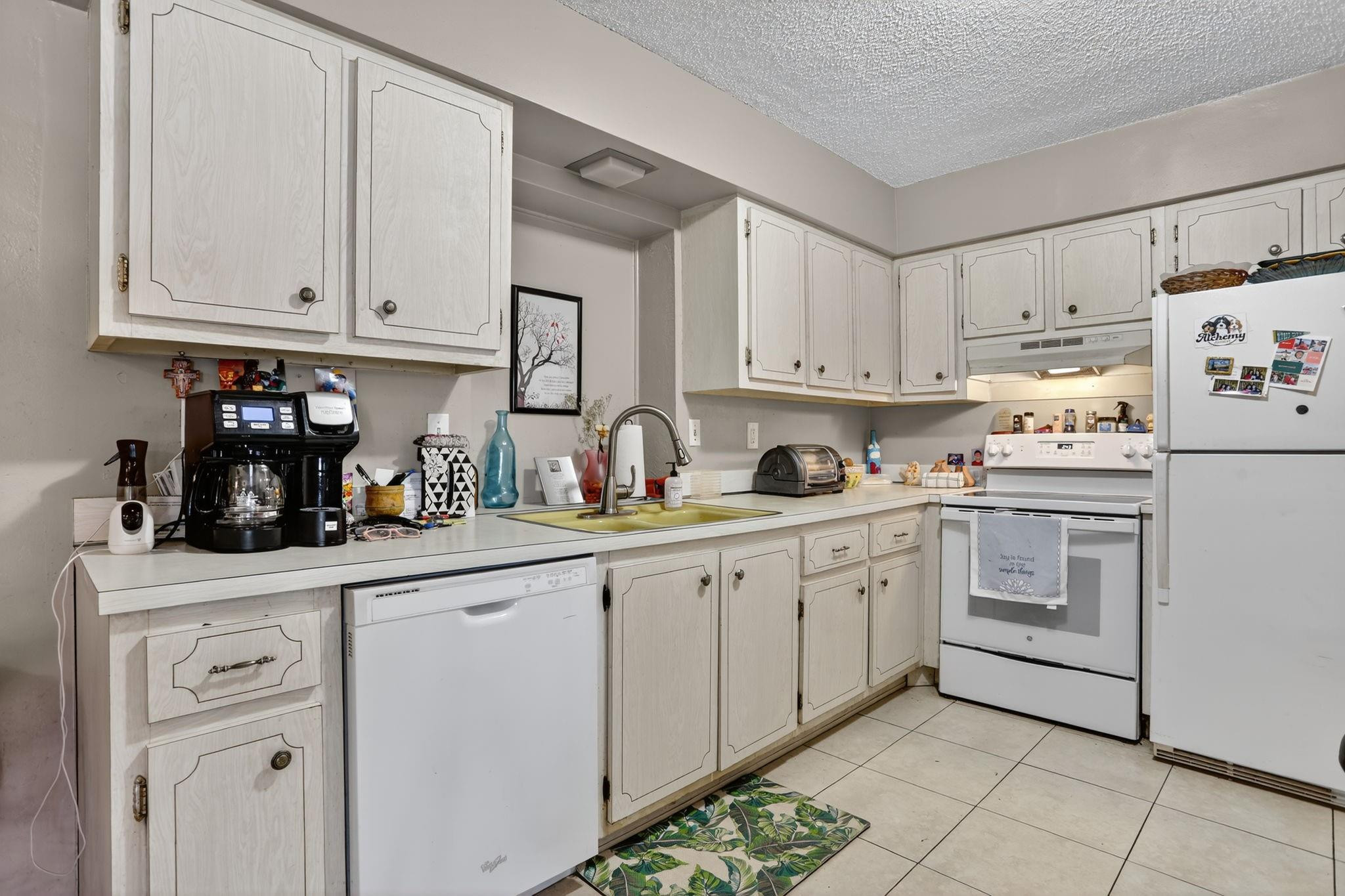 9806 Northwest 71st Street Tamarac, FL 33321 - Photo 11 of 23 a kitchen with granite countertop white cabinets and white appliances