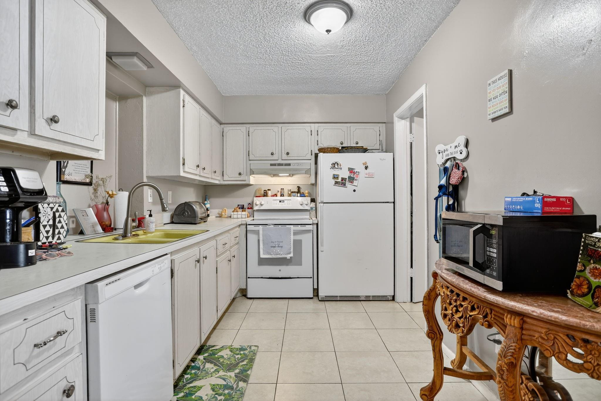 9806 Northwest 71st Street Tamarac, FL 33321 - Photo 10 of 23 a kitchen with a refrigerator sink and cabinets