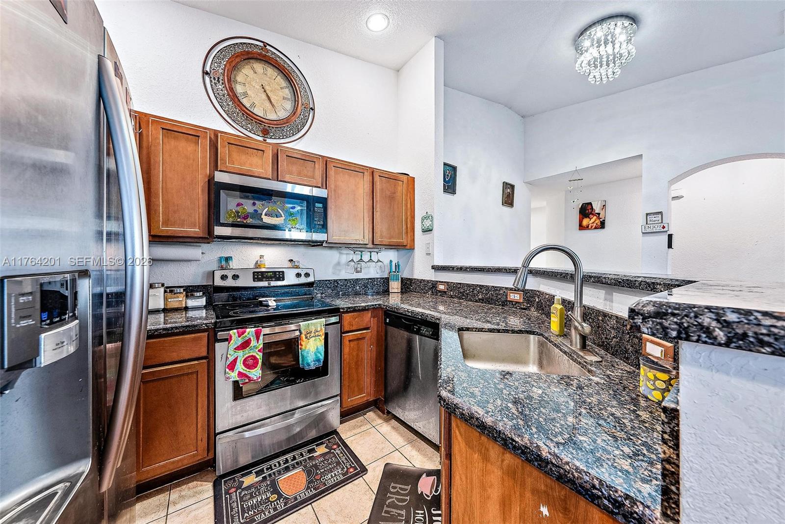 3229 Laurel Ridge Circle, Unit 3229 Riviera Beach, FL 33404 - Photo 7 of 24 a kitchen with stainless steel appliances granite countertop a stove a sink and a microwave