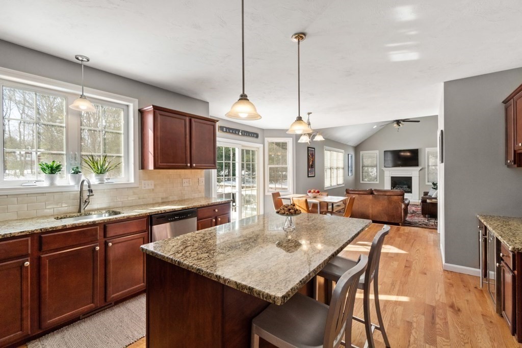 16 Michael Road Franklin, MA 02038 - Photo 11 of 39 a open kitchen with stainless steel appliances granite countertop a stove a sink a microwave a dining table chairs and a kitchen view