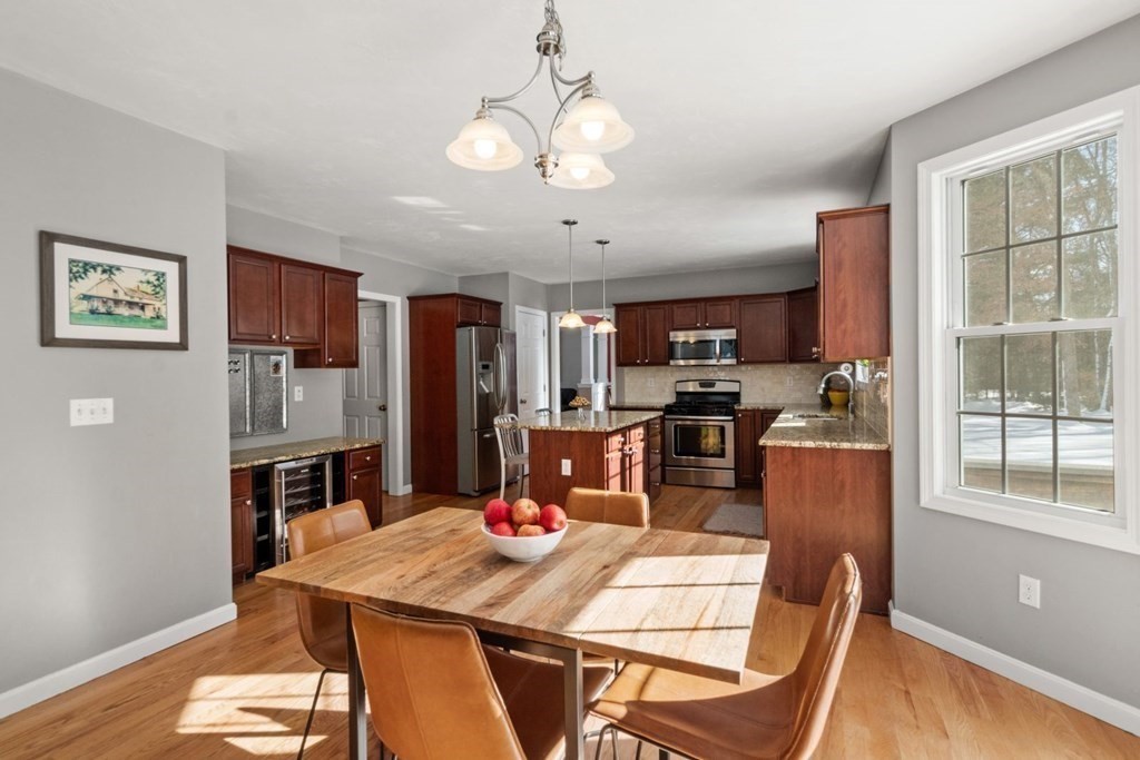16 Michael Road Franklin, MA 02038 - Photo 14 of 39 a kitchen with stainless steel appliances kitchen island granite countertop a refrigerator a stove top oven a sink dishwasher and a dining table with wooden floor