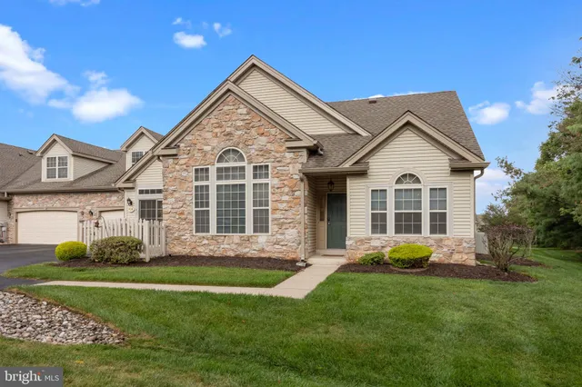 a front view of a house with a garden and yard