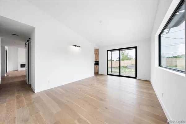 a large white room with a large window and stainless steel appliances