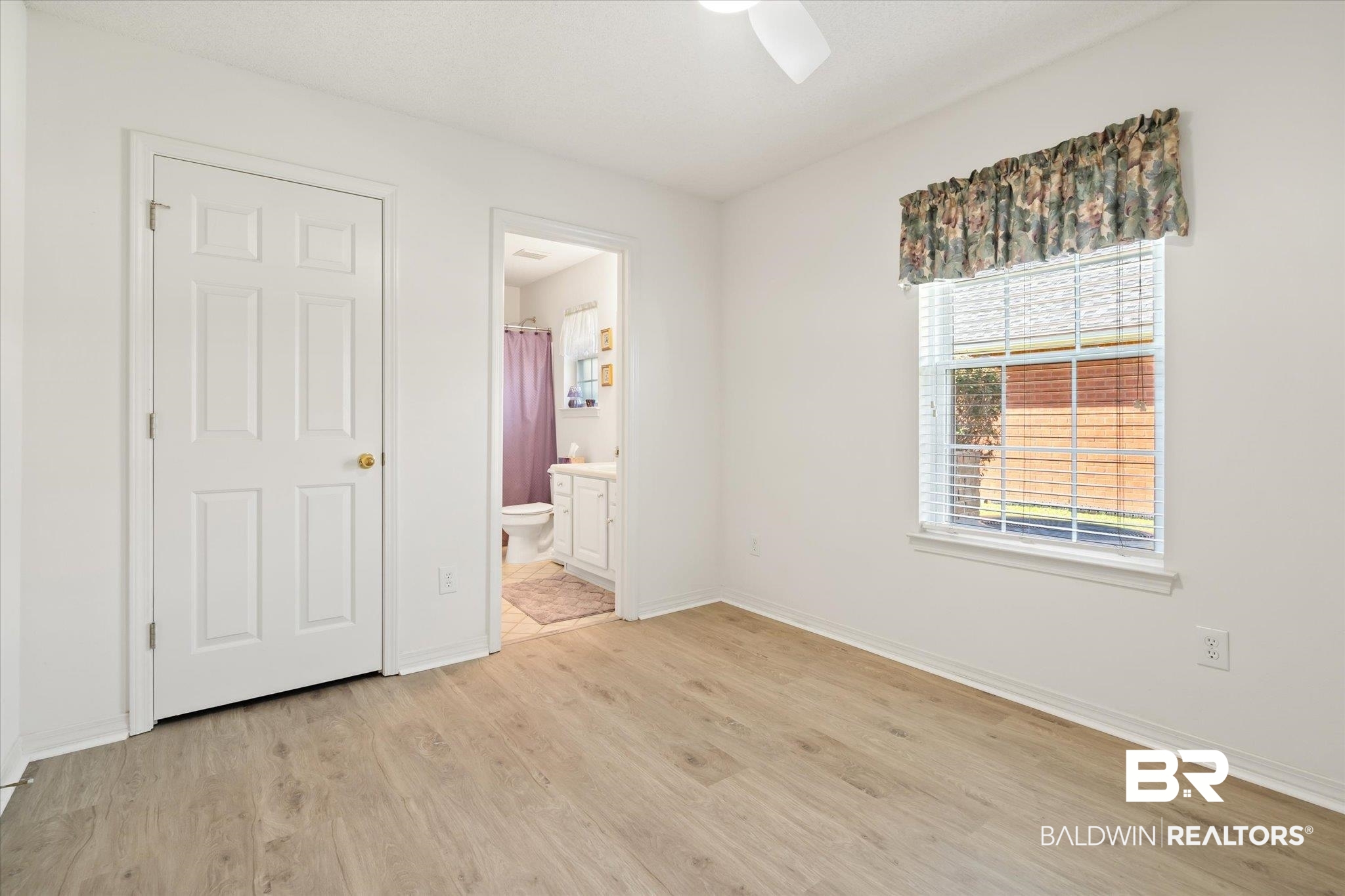 12520 Hunters Chase Foley, AL 36535 - Photo 28 of 32 Unfurnished bedroom featuring connected bathroom, baseboards, and light wood finished floors