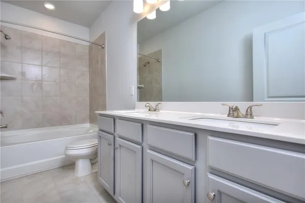 a bathroom with a granite countertop sink a toilet and a bathtub