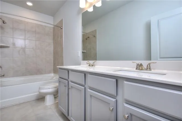 a bathroom with a granite countertop sink a toilet and a bathtub