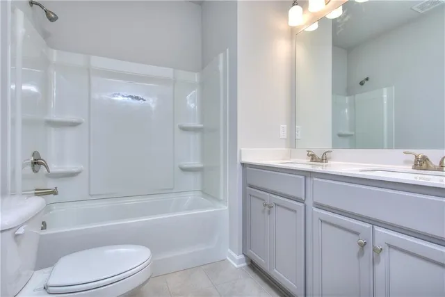 a bathroom with a bathtub shower sink vanity mirror and toilet