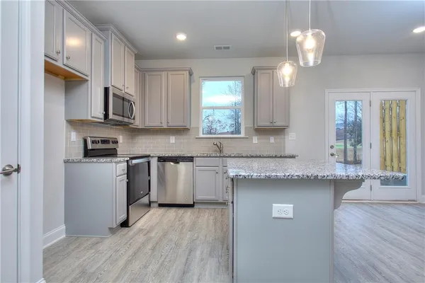 a kitchen with granite countertop wooden floors and cabinets