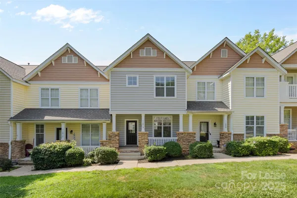 a front view of a house with a yard and plants