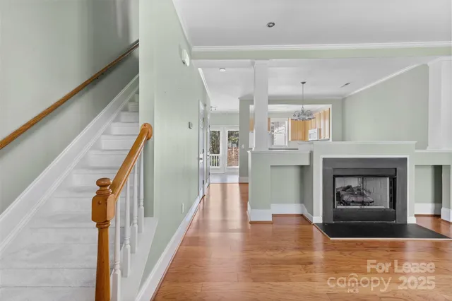 a view of a livingroom with wooden floor and a fireplace