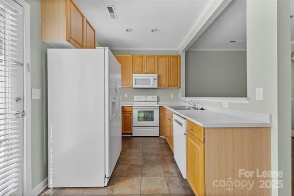 a kitchen with stainless steel appliances granite countertop a sink and a refrigerator