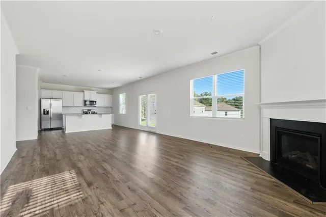 a view of empty room with wooden floor and fireplace