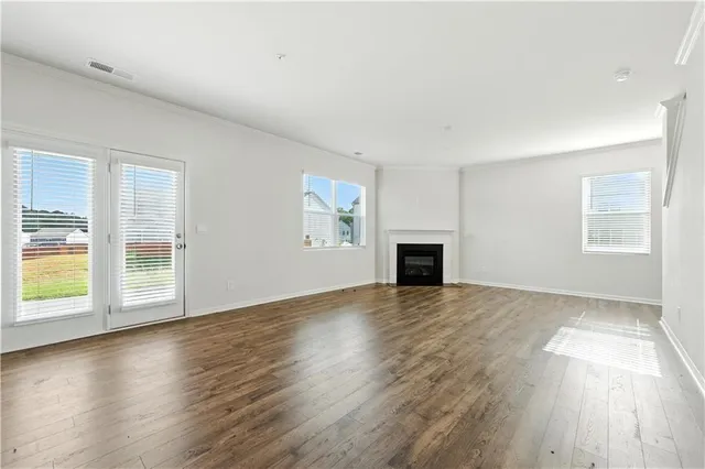 an empty room with wooden floor and fireplace