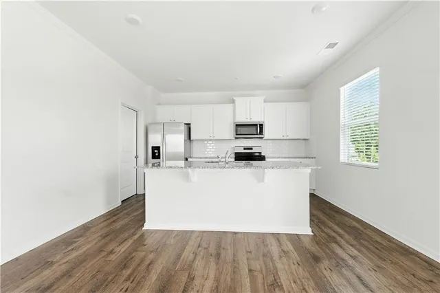 a view of kitchen with wooden floor and electronic appliances