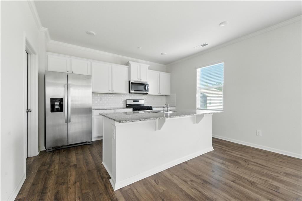 6753 Chilkat Court Southwest Atlanta, GA 30331 - Photo 8 of 16 a view of a kitchen with a sink refrigerator and wooden floor