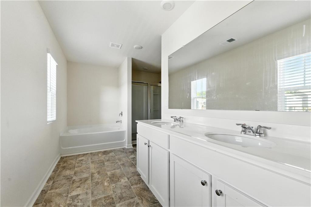 6753 Chilkat Court Southwest Atlanta, GA 30331 - Photo 10 of 16 a bathroom with a sink a mirror and a bathtub