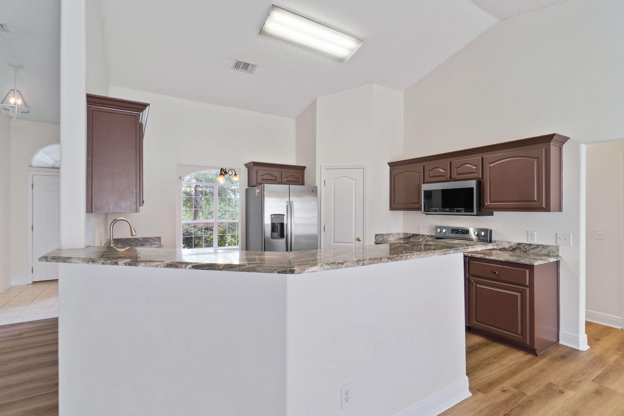 641 Territory Lane Crestview, FL 32536 - Photo 15 of 41 a kitchen with stainless steel appliances granite countertop a sink and a stove top oven with wooden floor
