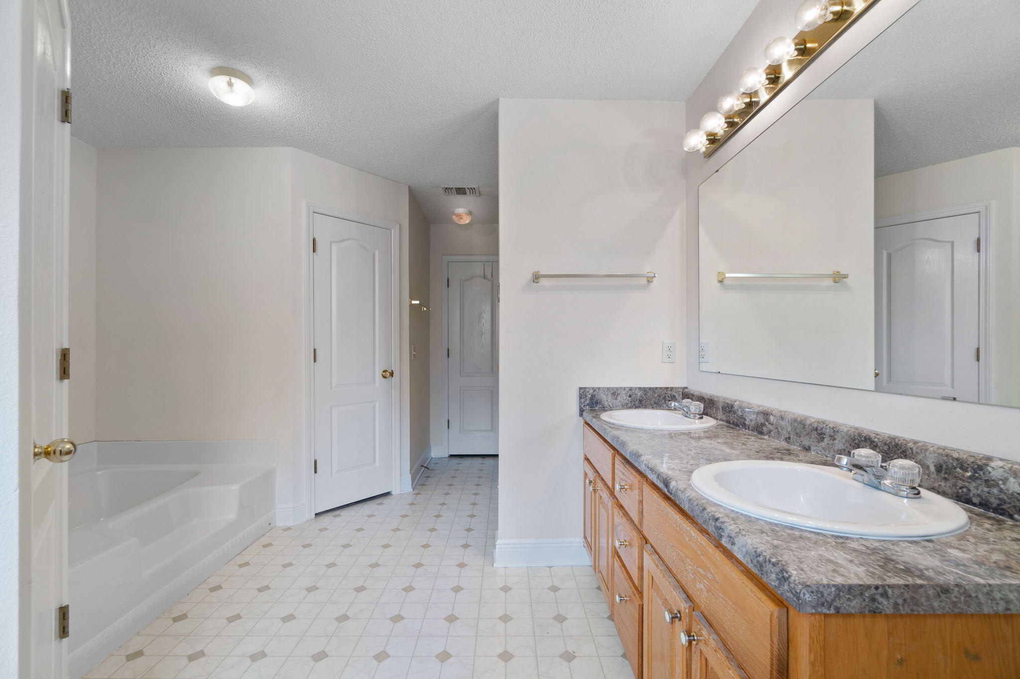 641 Territory Lane Crestview, FL 32536 - Photo 23 of 41 a bathroom with a granite countertop sink a mirror and a bathtub