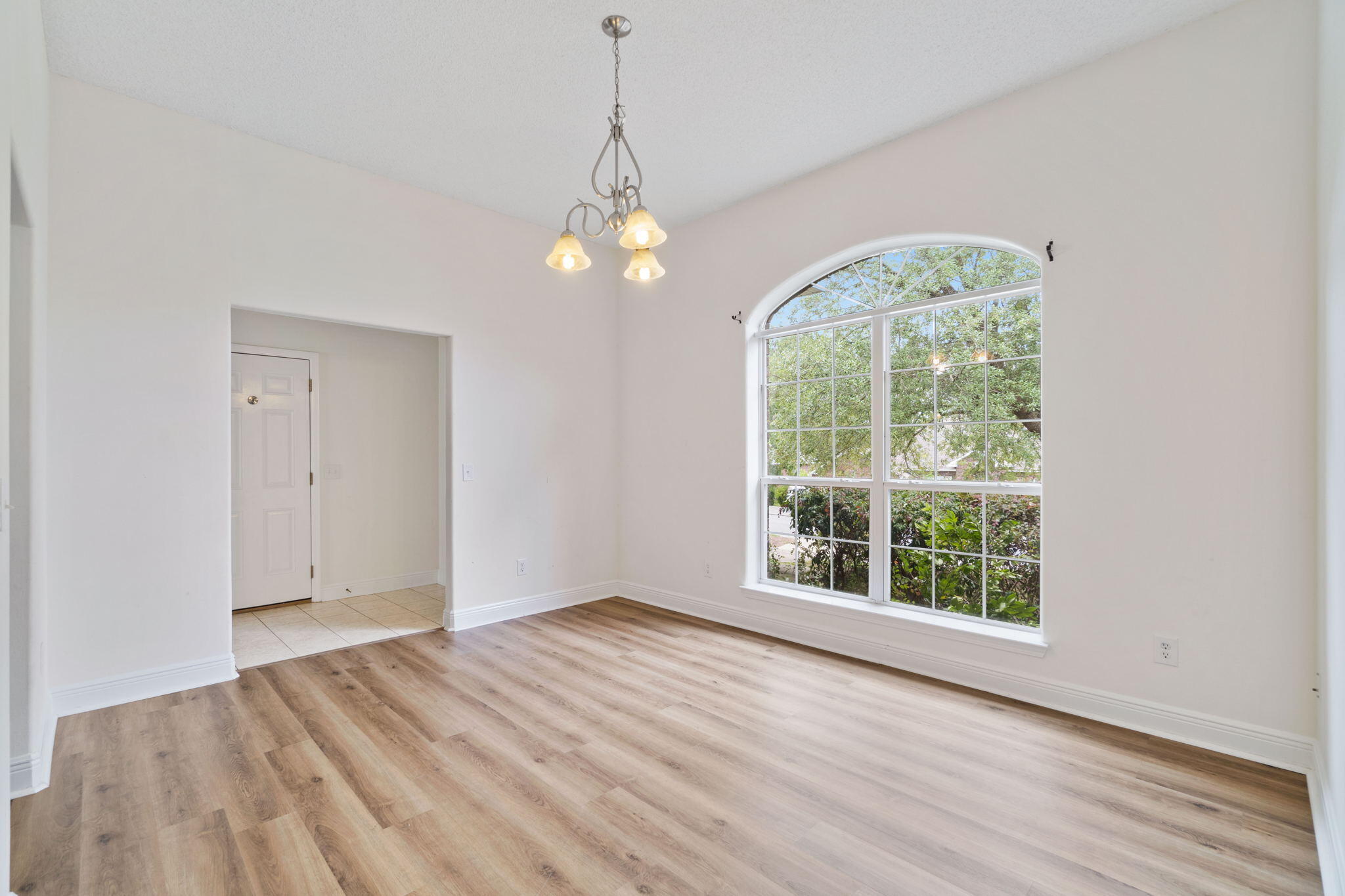 641 Territory Lane Crestview, FL 32536 - Photo 6 of 41 an empty room with wooden floor chandelier and window