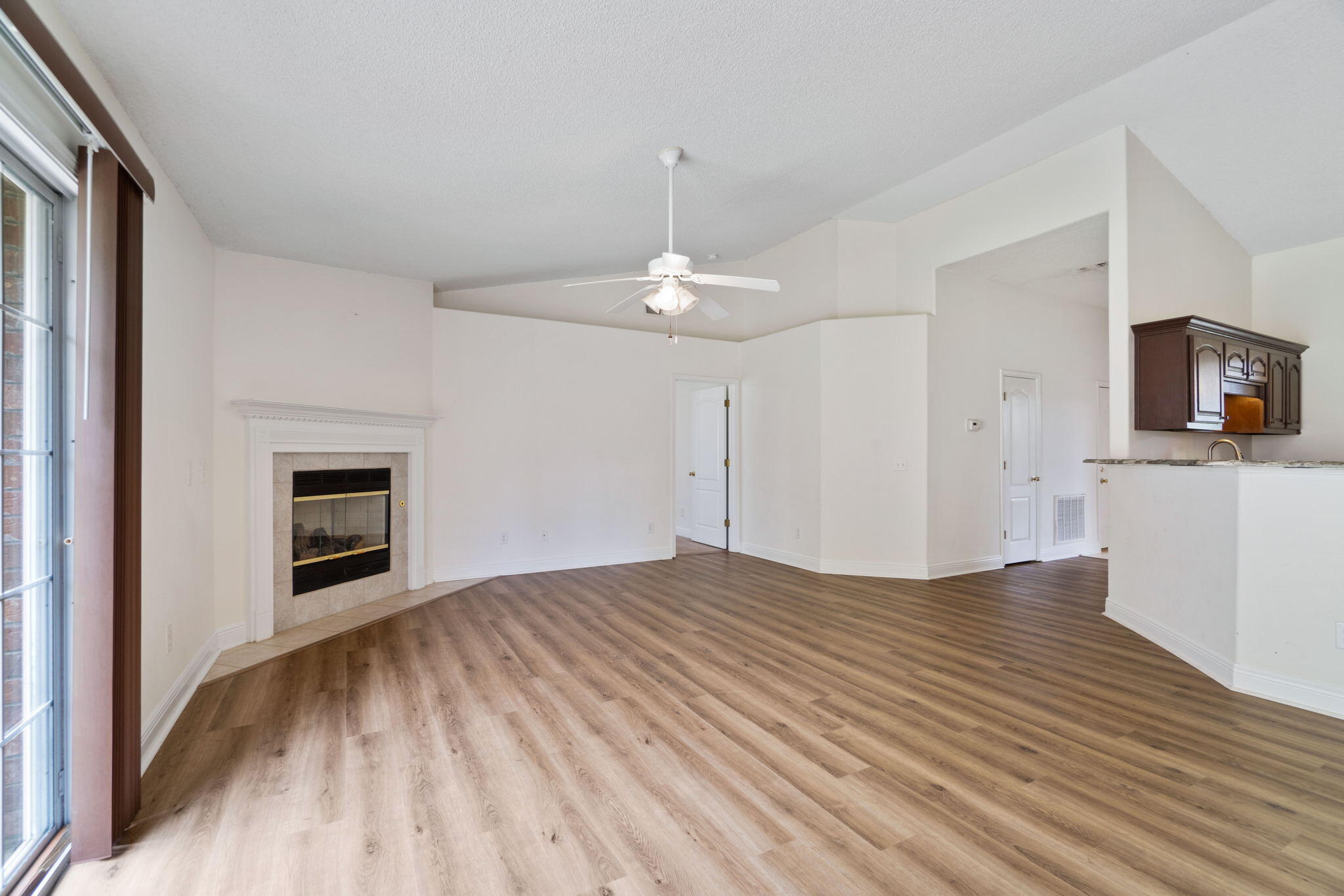 641 Territory Lane Crestview, FL 32536 - Photo 10 of 41 a view of a livingroom with a fireplace a ceiling fan and wooden floor