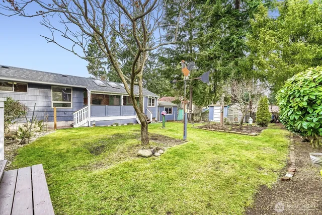 a view of a house with a backyard and a tree