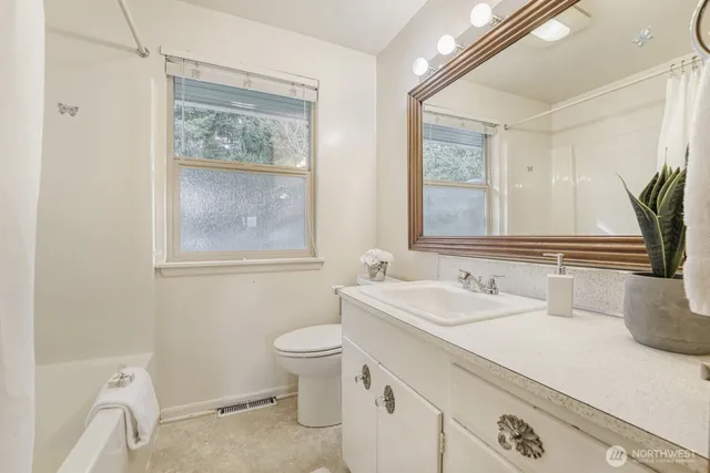 a bathroom with a granite countertop sink mirror vanity and toilet
