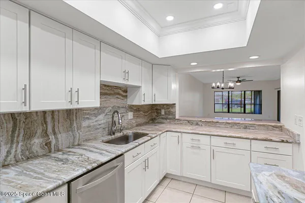 a kitchen with granite countertop a sink a stove and cabinets