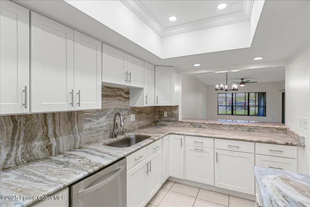 a kitchen with granite countertop a sink a stove and cabinets