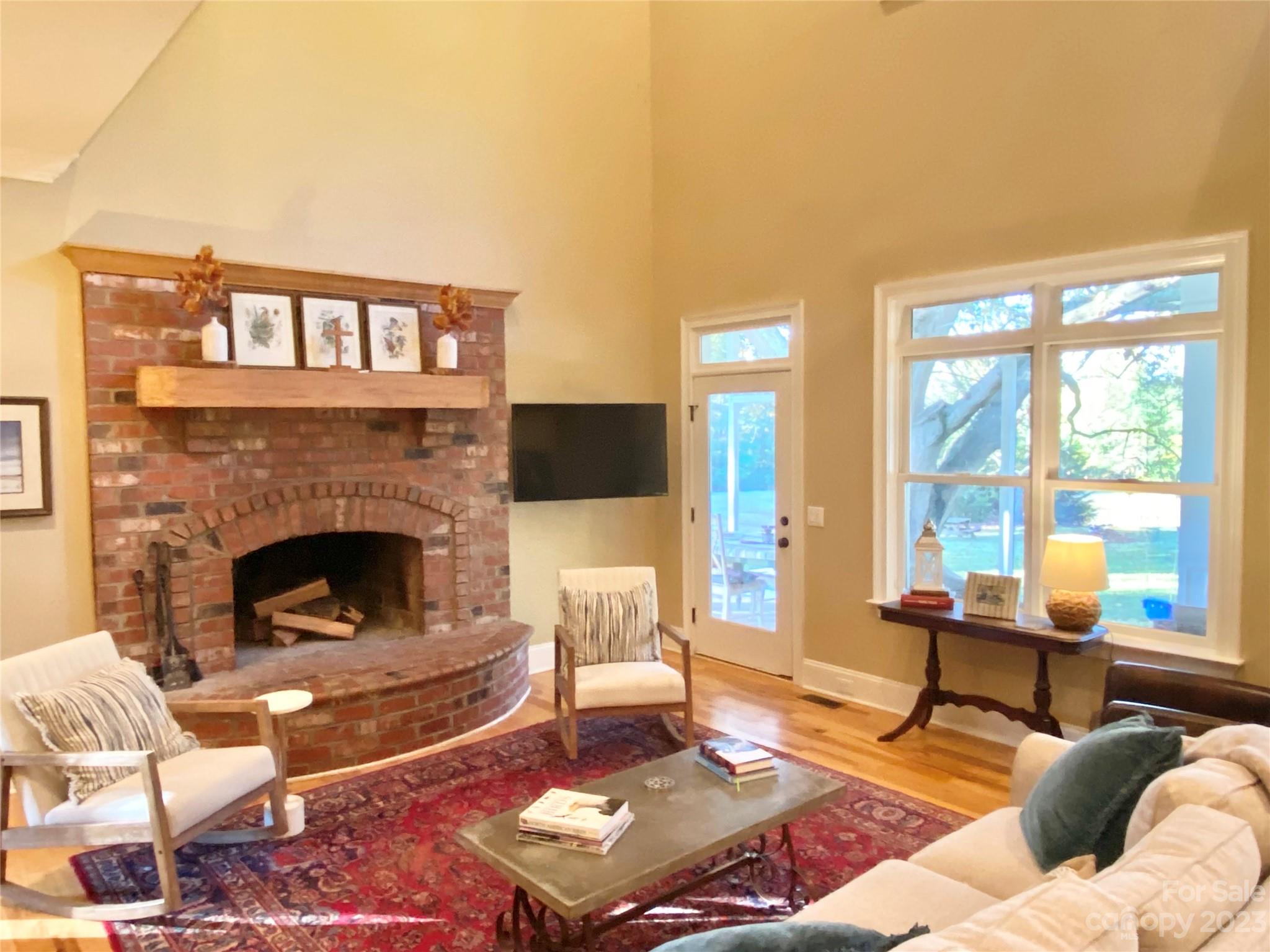 13849 Beatties Ford Road Huntersville, NC 28078 - Photo 16 of 48 a living room with furniture a fireplace and a floor to ceiling window
