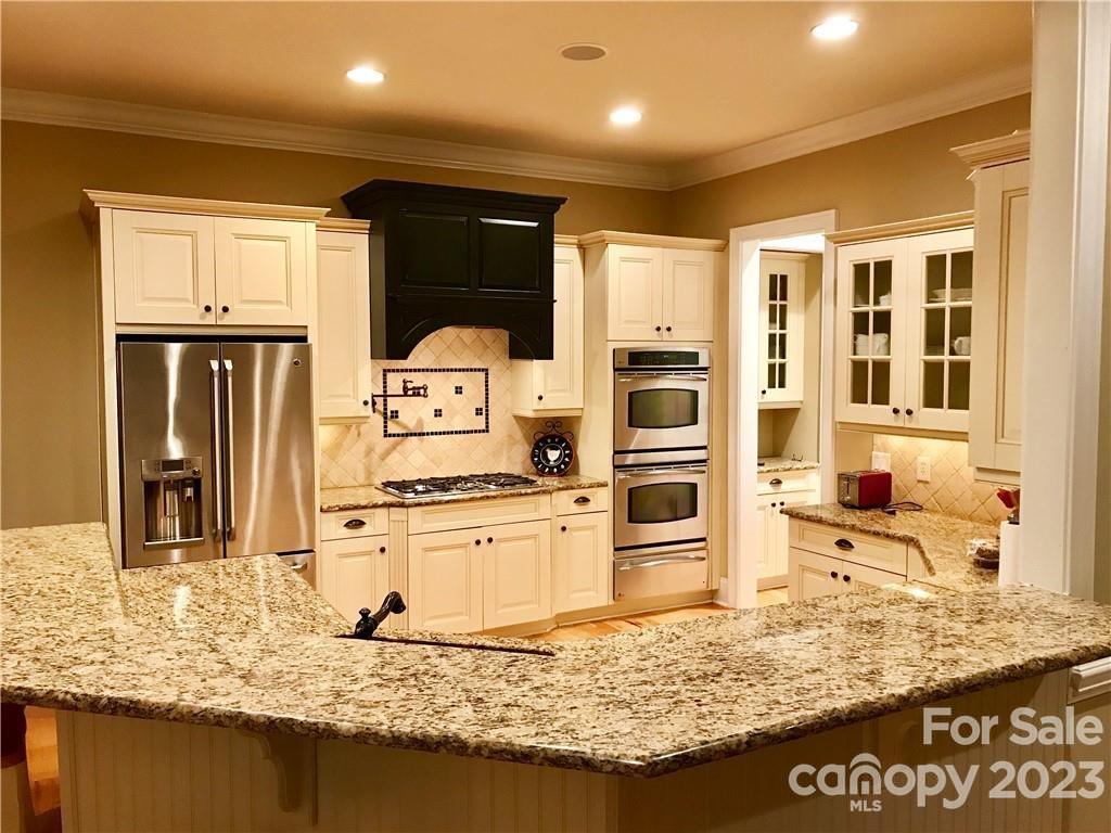 13849 Beatties Ford Road Huntersville, NC 28078 - Photo 20 of 48 a kitchen with stainless steel appliances granite countertop sink stove refrigerator and cabinets