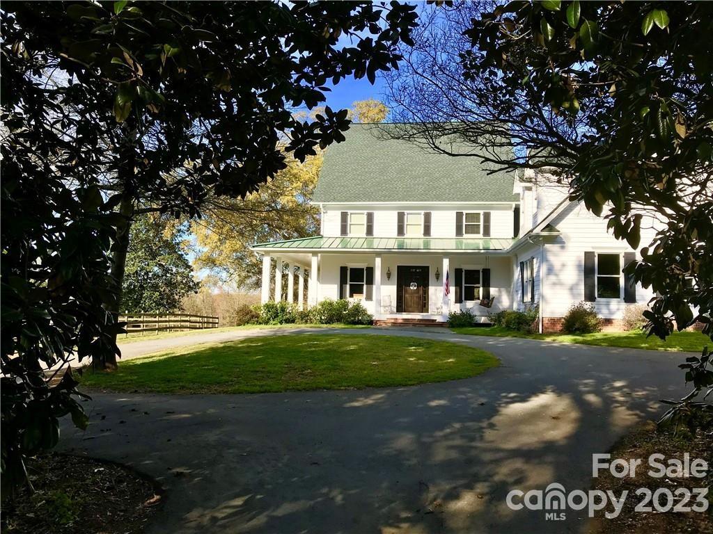 13849 Beatties Ford Road Huntersville, NC 28078 - Photo 5 of 48 a front view of a house with a garden