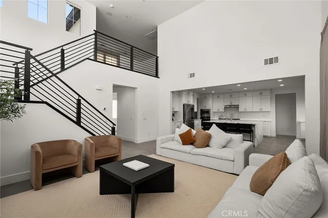 a living room with furniture and a view of kitchen