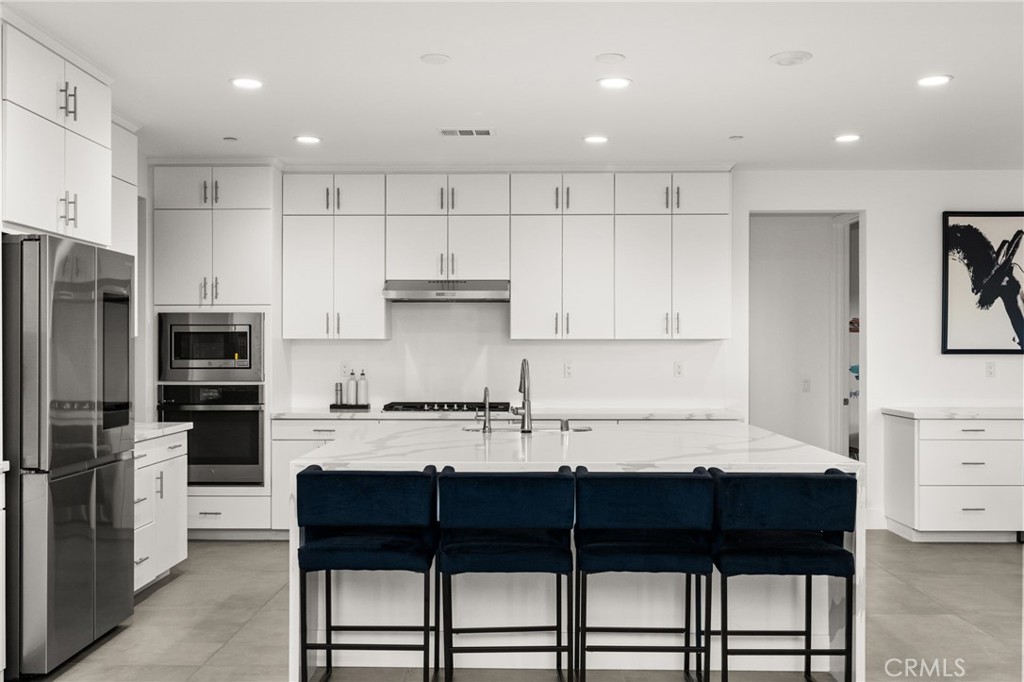 11401 West Serrano Square Yucaipa, CA 92399 - Photo 15 of 46 a kitchen with a table chairs refrigerator and cabinets