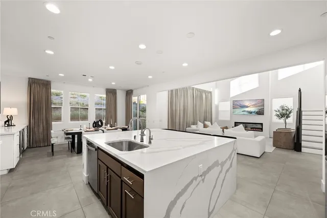 a large kitchen with kitchen island a sink a stove a refrigerator and white cabinets