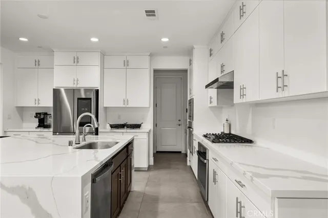 a kitchen with a sink a stove a refrigerator and a cabinets