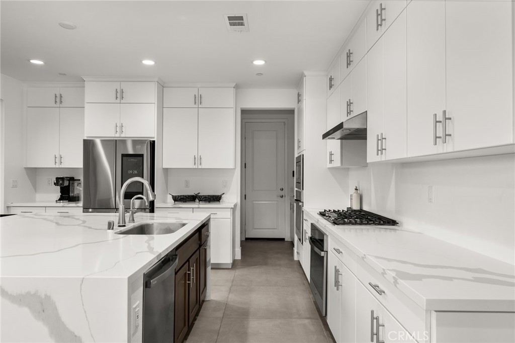 11401 West Serrano Square Yucaipa, CA 92399 - Photo 18 of 46 a kitchen with a sink a stove a refrigerator and a cabinets