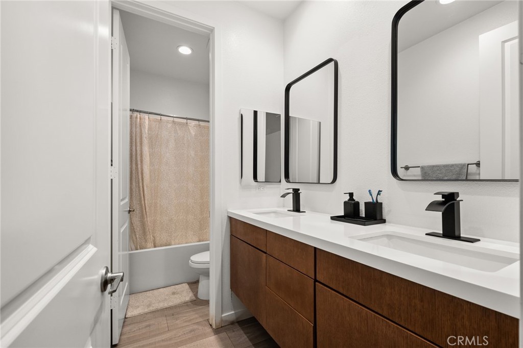 11401 West Serrano Square Yucaipa, CA 92399 - Photo 24 of 46 a bathroom with double vanity sink a toilet and a mirror